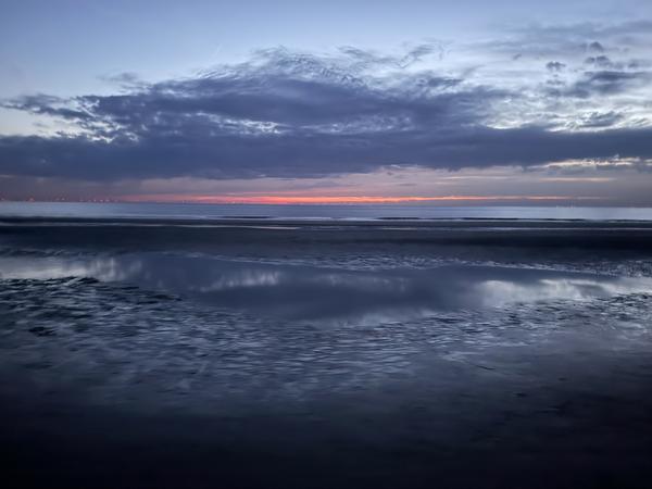 This photo captures a serene evening at Strandafgang Zuiderduin, Zandvoort, with the sky painted in hues of dark blue, grey, orange, and pink as dusk settles